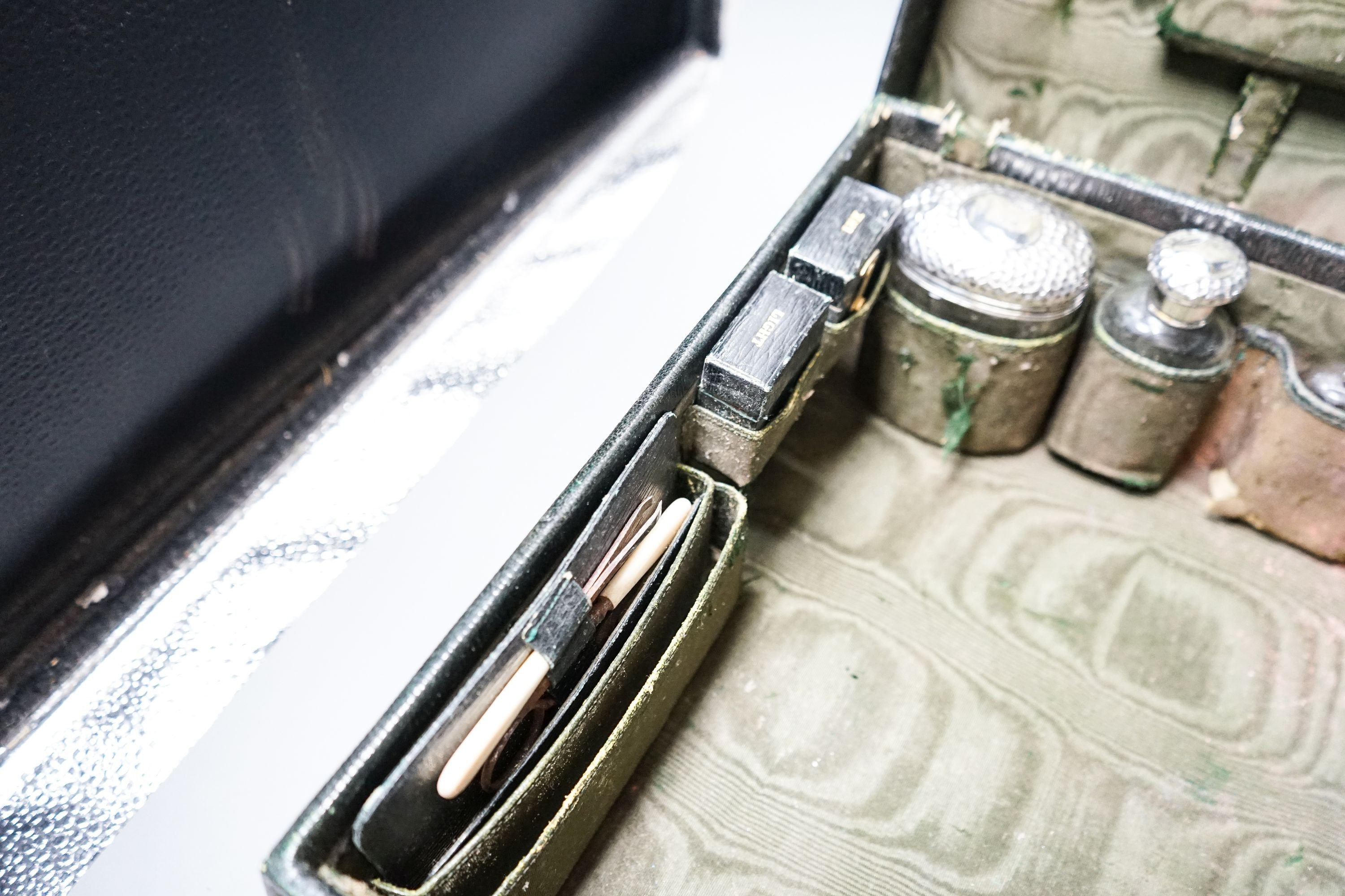 An Edwardian Harrod's traveling toilet case, fitted with six silver mounted toilet accessories, including an associated hip flask, case 40.3cm.